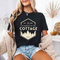 May include a person wearing a Black I’m Coming to the Cottage T-Shirt featuring rivalry inspired graphic design and relaxed fit.