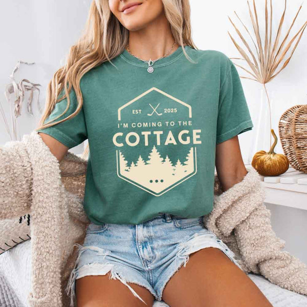 May include a person wearing a Light Green  I’m Coming to the Cottage T-Shirt featuring rivalry inspired graphic design and relaxed fit.