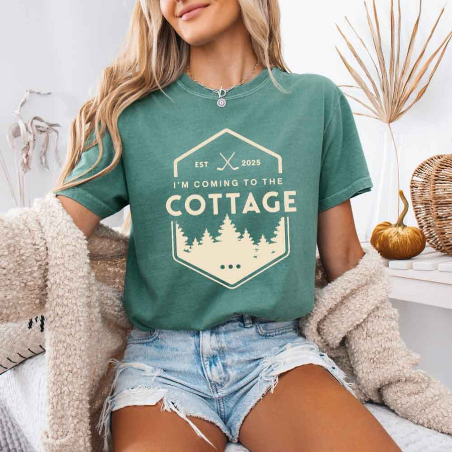 May include a person wearing a Light Green  I’m Coming to the Cottage T-Shirt featuring rivalry inspired graphic design and relaxed fit.