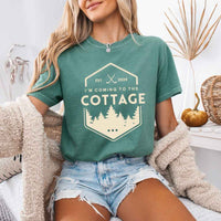 May include a person wearing a Light Green  I’m Coming to the Cottage T-Shirt featuring rivalry inspired graphic design and relaxed fit.