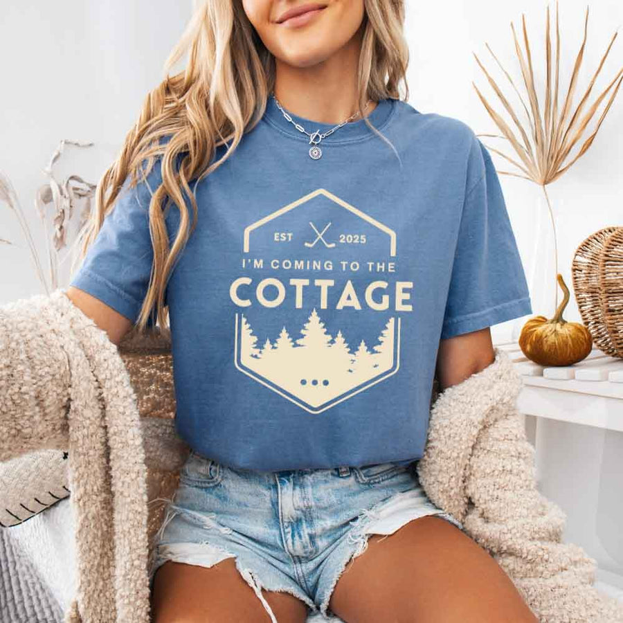 May include a person wearing a Blue Jean I’m Coming to the Cottage T-Shirt featuring rivalry inspired graphic design and relaxed fit.