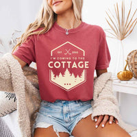 May include a person wearing a Crimson I’m Coming to the Cottage T-Shirt featuring rivalry inspired graphic design and relaxed fit.