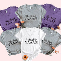 Collection of t-shirts with 'She Said YAAAS!' and 'I Said YAAAS!' text on a pink background.