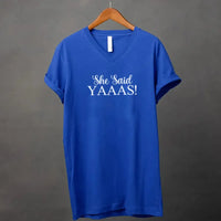 Blue t-shirt with 'She Said YAAAS!' text on a hanger against a gray background