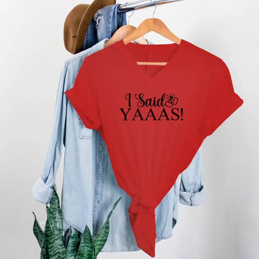 Red t-shirt with 'I Said YAAAS!' text on a hanger with denim shirt and hat.