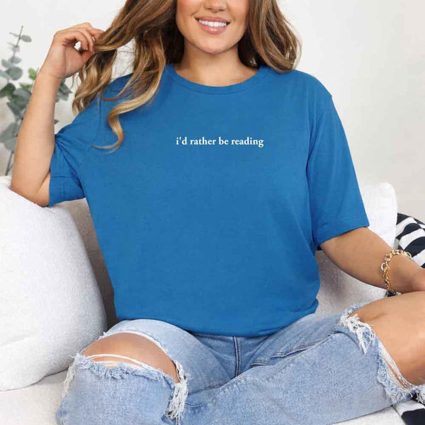 May include a person wearing a sapphire I'd Rather Be Reading T-Shirt featuring trendy book lover graphic and relaxed fit.
