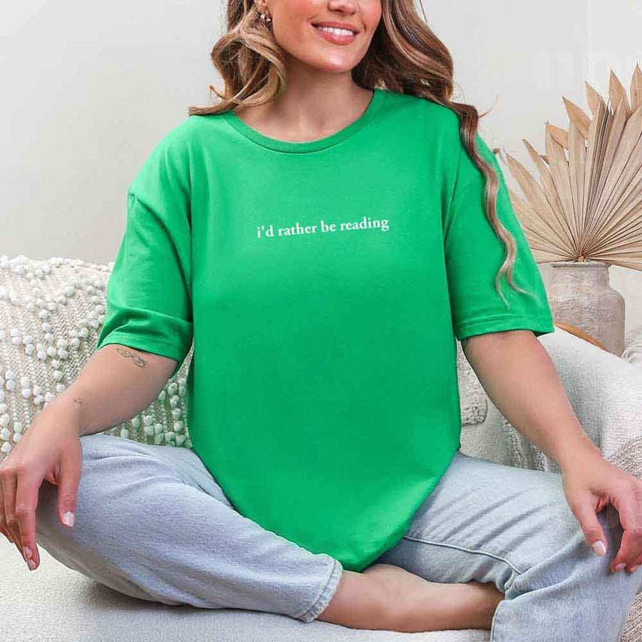May include a person wearing a green  I'd Rather Be Reading T-Shirt featuring trendy book lover graphic and relaxed fit.
