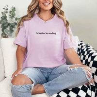 May include a person wearing a lilac I'd Rather Be Reading T-Shirt featuring trendy book lover graphic and relaxed fit.
