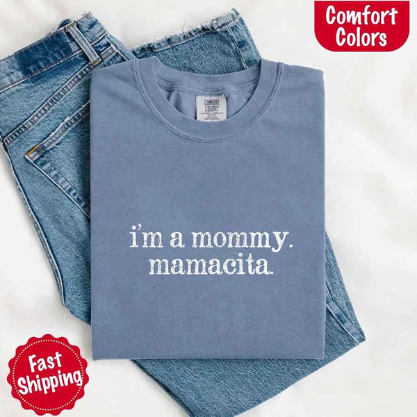 May include a women’s Comfort Colors t-shirt featuring the phrase “I’m a Mommy” or “Mamacita” in stylish, playful lettering, designed with a soft, lived-in look that celebrates motherhood with a confident and fun tone.