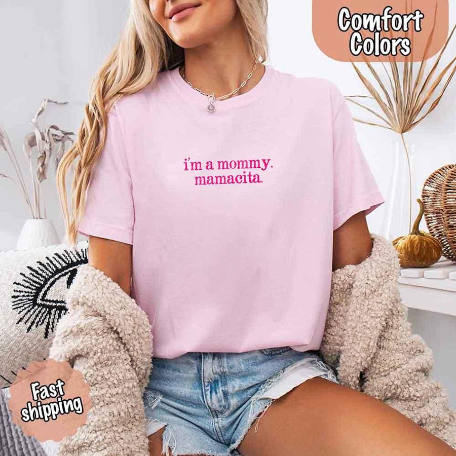 May include a women’s Comfort Colors t-shirt featuring the phrase “I’m a Mommy” or “Mamacita” in stylish, playful lettering, designed with a soft, lived-in look that celebrates motherhood with a confident and fun tone.