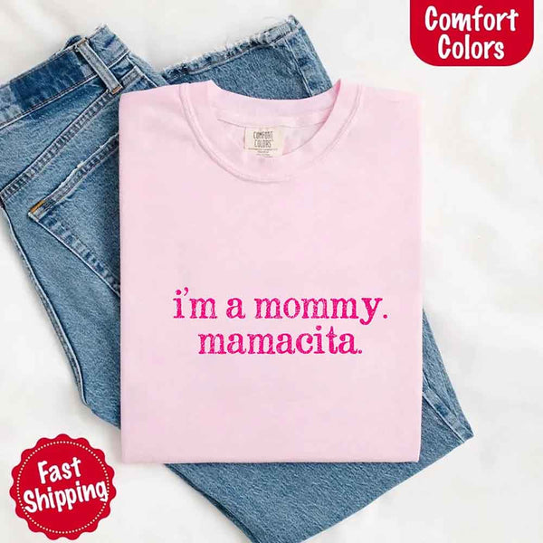 May include a women’s Comfort Colors t-shirt featuring the phrase “I’m a Mommy” or “Mamacita” in stylish, playful lettering, designed with a soft, lived-in look that celebrates motherhood with a confident and fun tone.