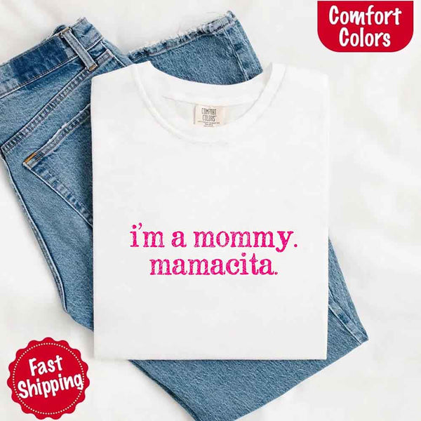 May include a women’s Comfort Colors t-shirt featuring the phrase “I’m a Mommy” or “Mamacita” in stylish, playful lettering, designed with a soft, lived-in look that celebrates motherhood with a confident and fun tone.