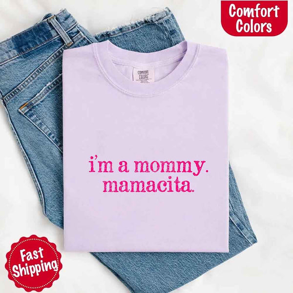 May include a women’s Comfort Colors t-shirt featuring the phrase “I’m a Mommy” or “Mamacita” in stylish, playful lettering, designed with a soft, lived-in look that celebrates motherhood with a confident and fun tone.