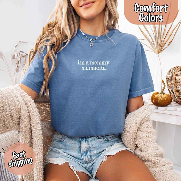 May include a women’s Comfort Colors t-shirt featuring the phrase “I’m a Mommy” or “Mamacita” in stylish, playful lettering, designed with a soft, lived-in look that celebrates motherhood with a confident and fun tone.
