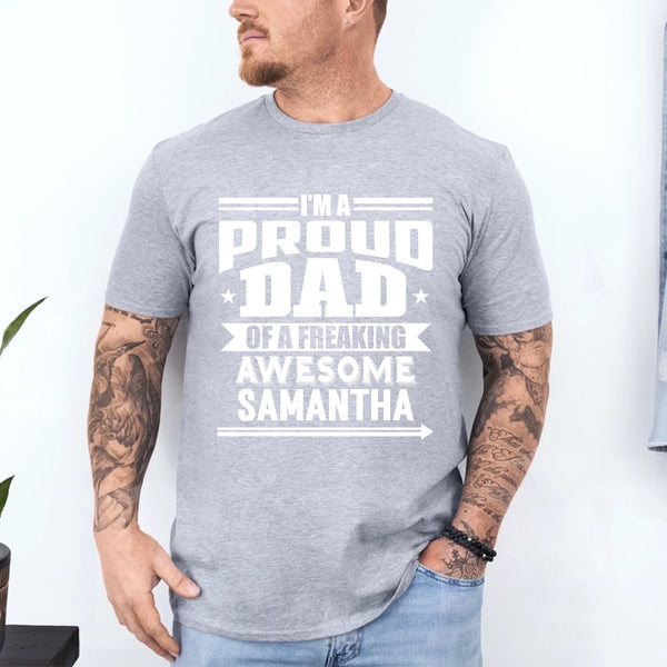 May include a father and child wearing matching t-shirts reading “I’m A Proud Dad” and “Me”