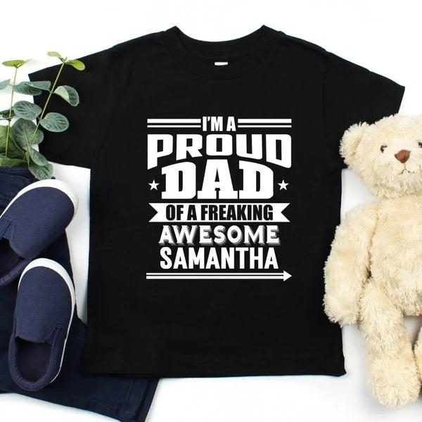 May include a father and child wearing matching t-shirts reading “I’m A Proud Dad” and “Me”