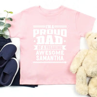May include a father and child wearing matching t-shirts reading “I’m A Proud Dad” and “Me”