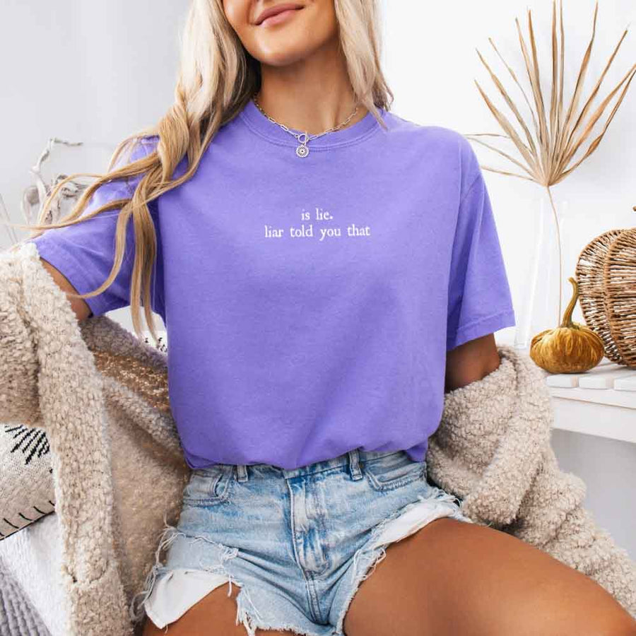 May include a person wearing a Violet Is Lie Liar Told You That Comfort Colors T-Shirt featuring rivalry inspired graphic and relaxed fit.