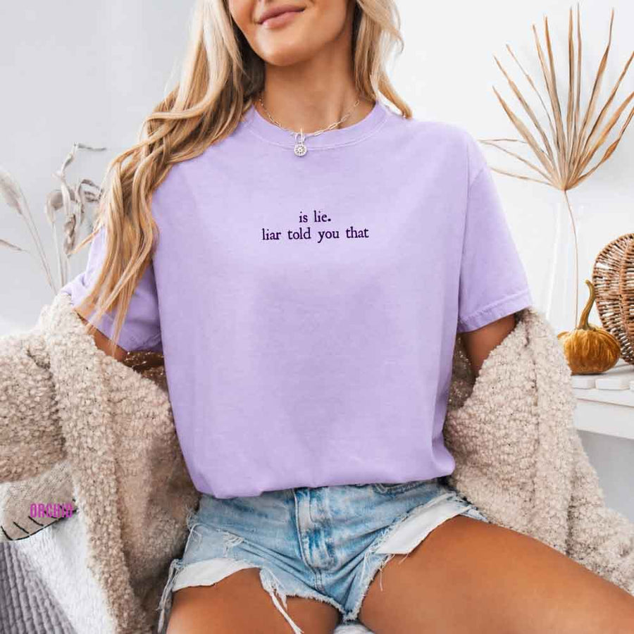 May include a person wearing an Orchid Is Lie Liar Told You That Comfort Colors T-Shirt featuring rivalry inspired graphic and relaxed fit.