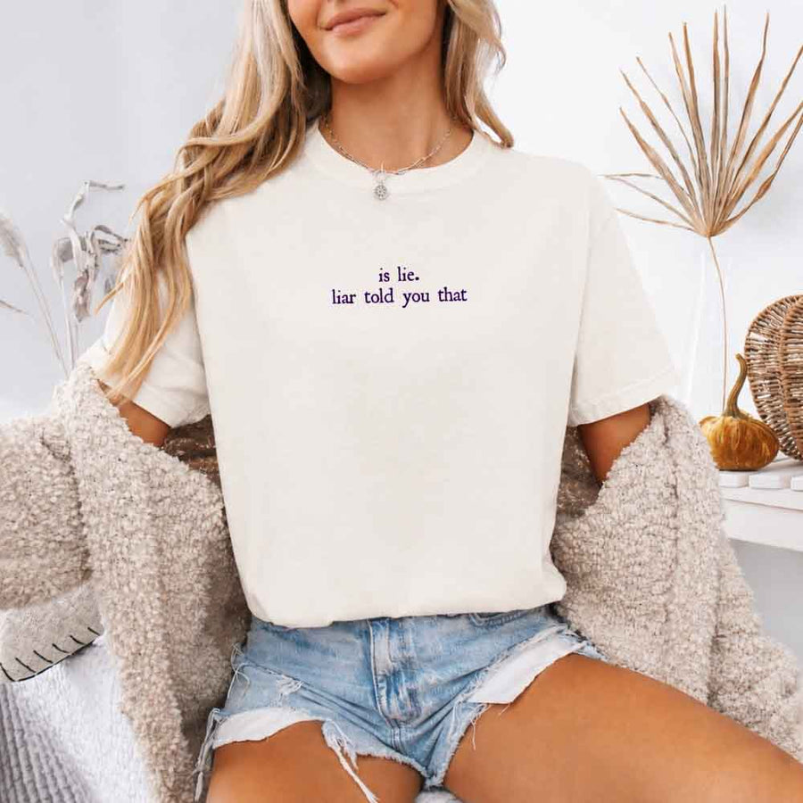 May include a person wearing a Ivory Is Lie Liar Told You That Comfort Colors T-Shirt featuring rivalry inspired graphic and relaxed fit.