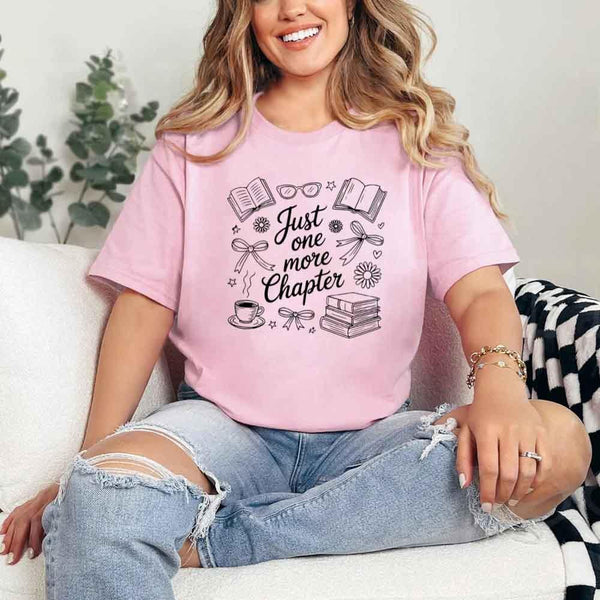 May include a person wearing a Pink Just One More Chapter T-Shirt featuring trendy book lover graphic and relaxed fit.