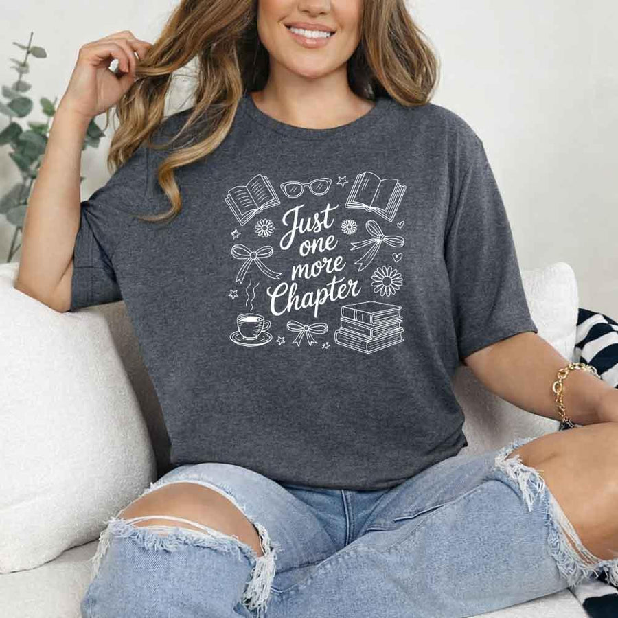 May include a person wearing a Dark Heather Just One More Chapter T-Shirt featuring trendy book lover graphic and relaxed fit.