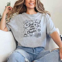 May include a person wearing a Sport Grey Just One More Chapter T-Shirt featuring trendy book lover graphic and relaxed fit.