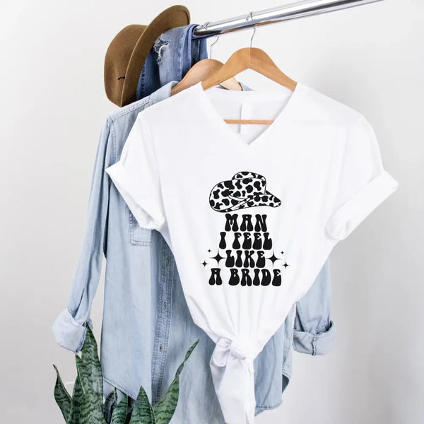 May include White “Man I Feel Like a Bride” matching V-neck t-shirt for bachelorette party, bride squad country themed design.