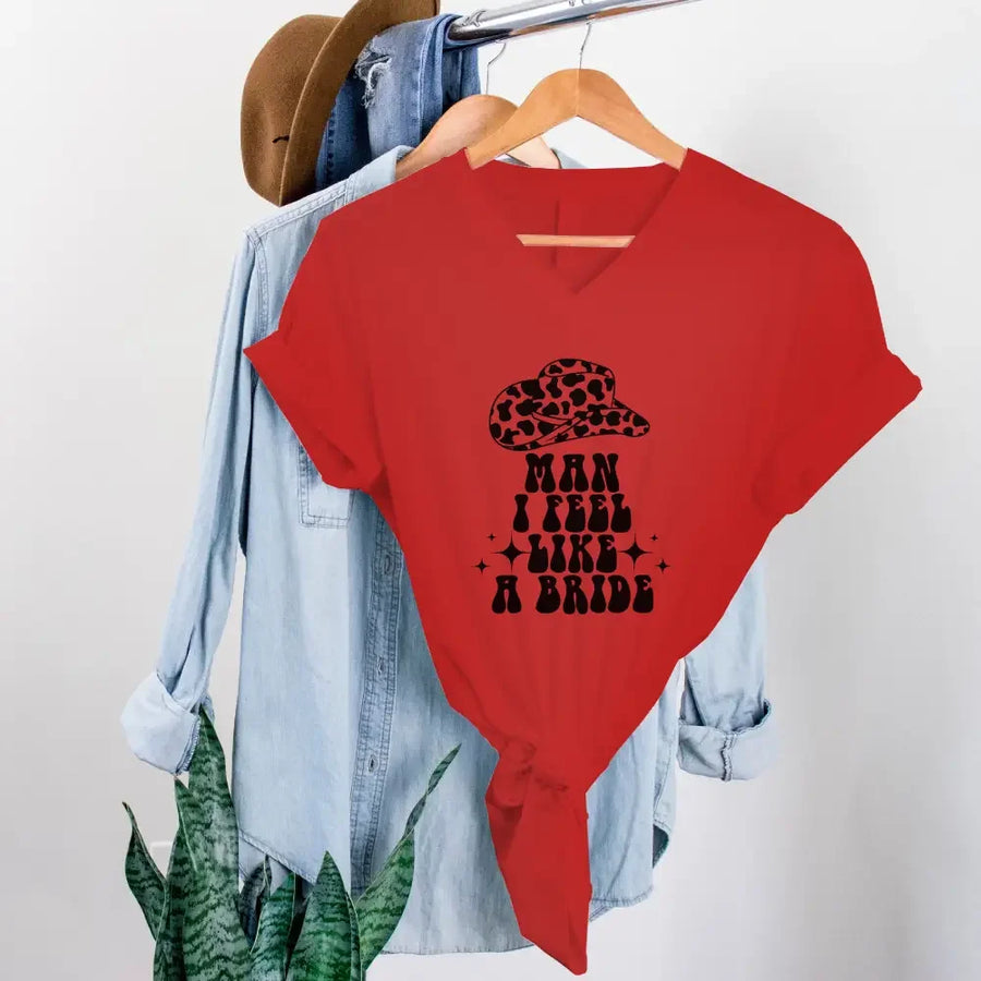 Red t-shirt with graphic design and text on a hanger with denim jacket and hat.