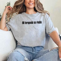 May include a person wearing a grey colored graphic t-shirt with the Spanish phrase “Mi Terapeuta Se Rindió”.
