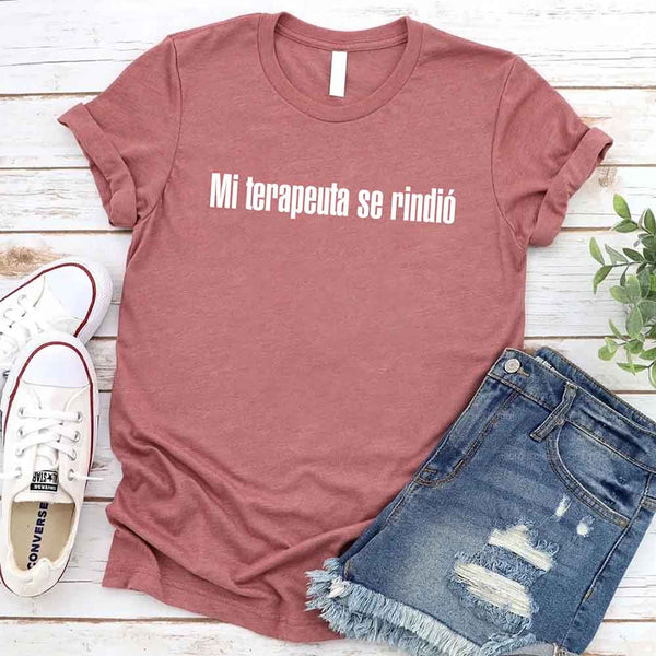 May include a person wearing a mauve colored graphic t-shirt with the Spanish phrase “Mi Terapeuta Se Rindió”.