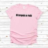 May include a person wearing a pink colored graphic t-shirt with the Spanish phrase “Mi Terapeuta Se Rindió”.