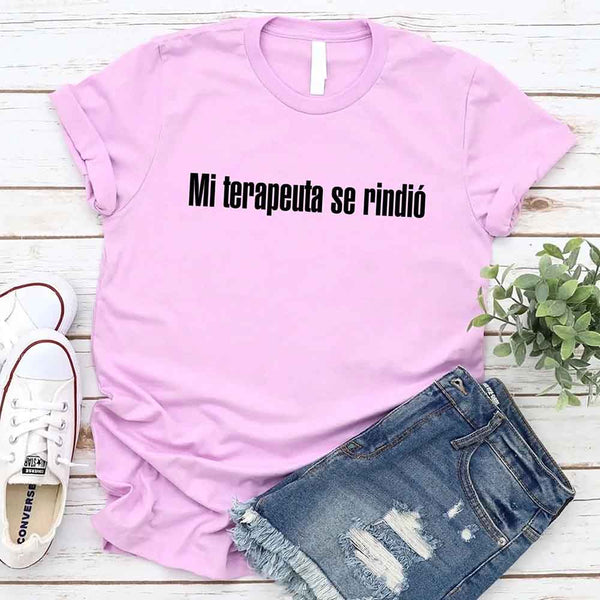 May include a person wearing a lilac colored graphic t-shirt with the Spanish phrase “Mi Terapeuta Se Rindió”.