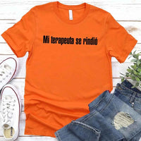 May include a person wearing a orange colored graphic t-shirt with the Spanish phrase “Mi Terapeuta Se Rindió”.