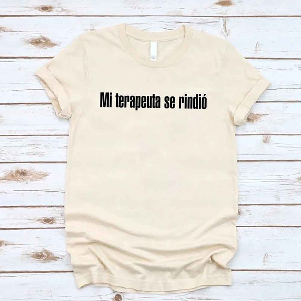 May include a person wearing a cream colored graphic t-shirt with the Spanish phrase “Mi Terapeuta Se Rindió”.