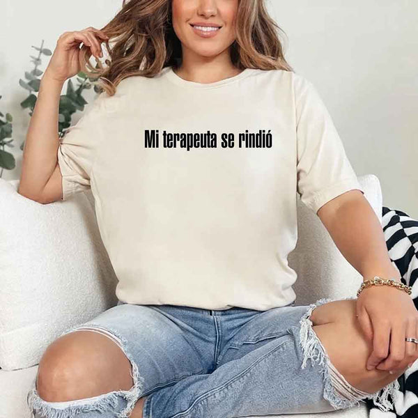 May include a person wearing a cream colored graphic t-shirt with the Spanish phrase “Mi Terapeuta Se Rindió”.