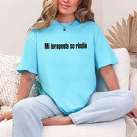 May include a person wearing a turqoise colored graphic t-shirt with the Spanish phrase “Mi Terapeuta Se Rindió”.