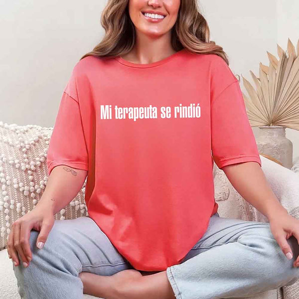May include a person wearing a heliconia colored graphic t-shirt with the Spanish phrase “Mi Terapeuta Se Rindió”.