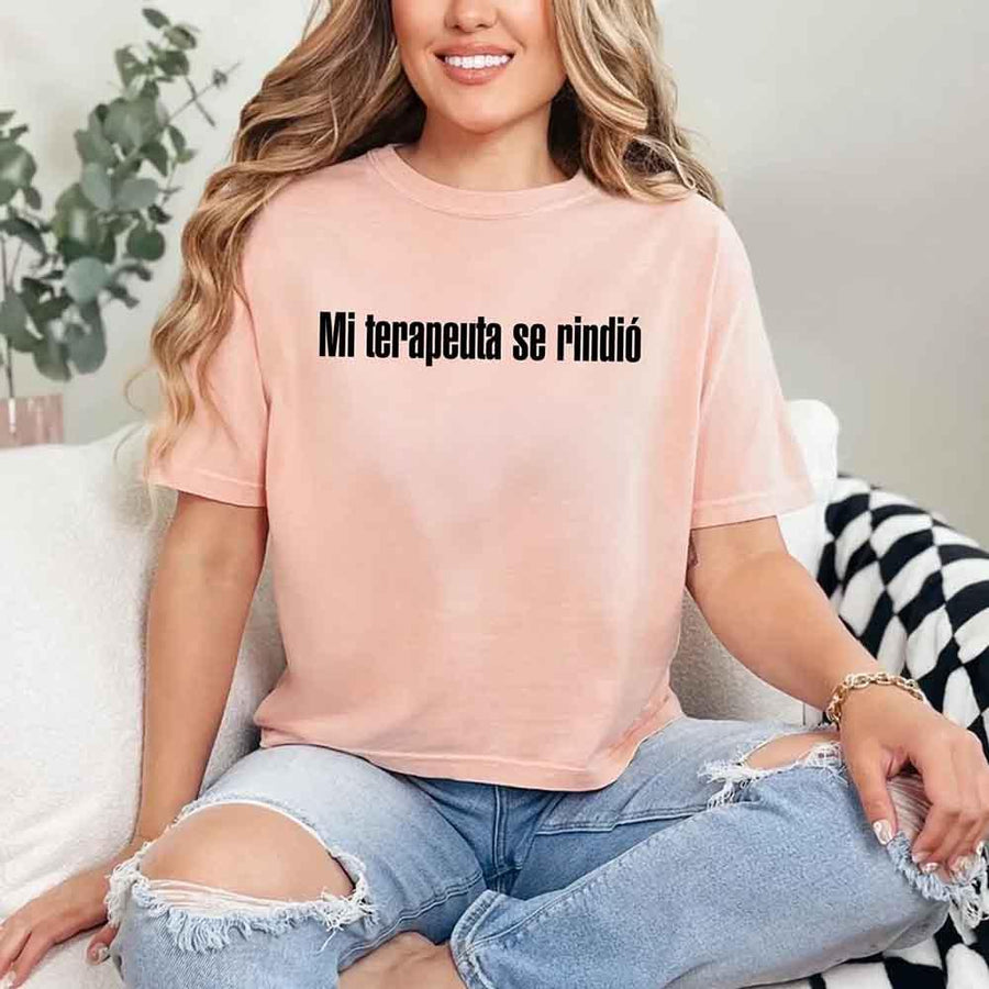 May include a person wearing a peach colored graphic t-shirt with the Spanish phrase “Mi Terapeuta Se Rindió”.