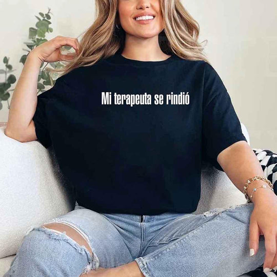 May include a person wearing a black colored graphic t-shirt with the Spanish phrase “Mi Terapeuta Se Rindió”.