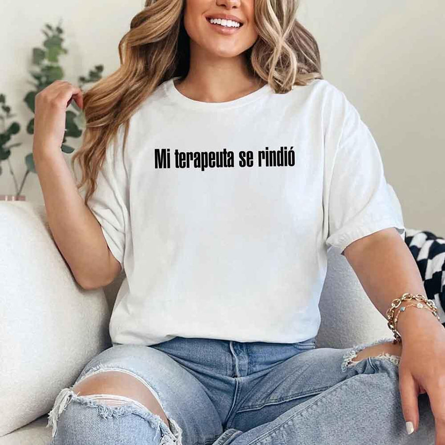 May include a person wearing a white colored graphic t-shirt with the Spanish phrase “Mi Terapeuta Se Rindió”.