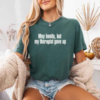 May include a person wearing a blue spruce colored sarcastic graphic t-shirt with the phrase “Muy Bonita But My Therapist Gave Up”.
