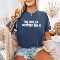 May include a person wearing a denim colored sarcastic graphic t-shirt with the phrase “Muy Bonita But My Therapist Gave Up”.
