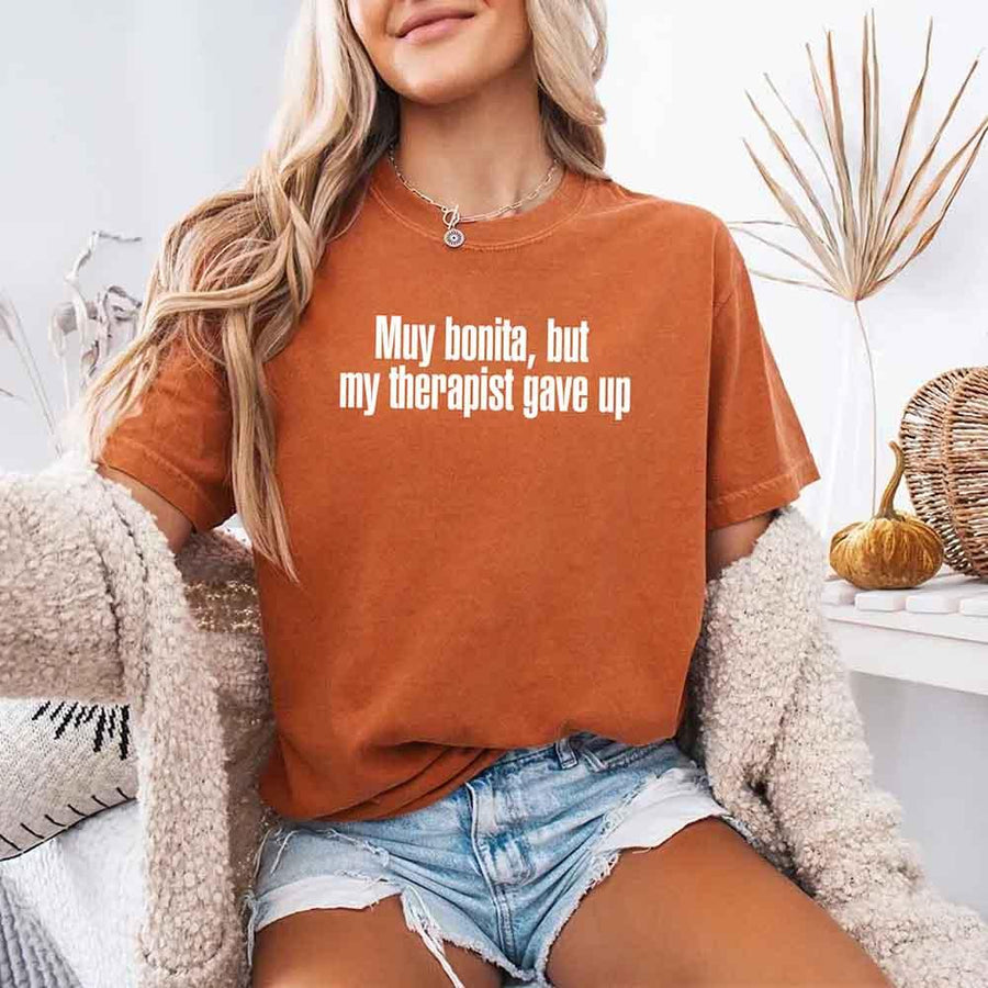 May include a person wearing a yam colored sarcastic graphic t-shirt with the phrase “Muy Bonita But My Therapist Gave Up”.
