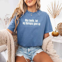 May include a person wearing a blue jean colored sarcastic graphic t-shirt with the phrase “Muy Bonita But My Therapist Gave Up”.
