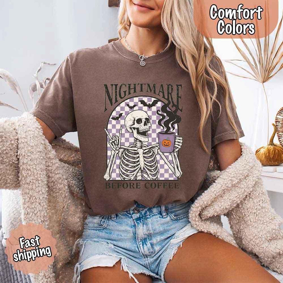 May include a Halloween Comfort Colors shirt with skeleton design and “Nightmare Before Coffee” text.