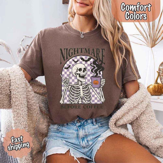 May include a Halloween Comfort Colors shirt with skeleton design and “Nightmare Before Coffee” text.