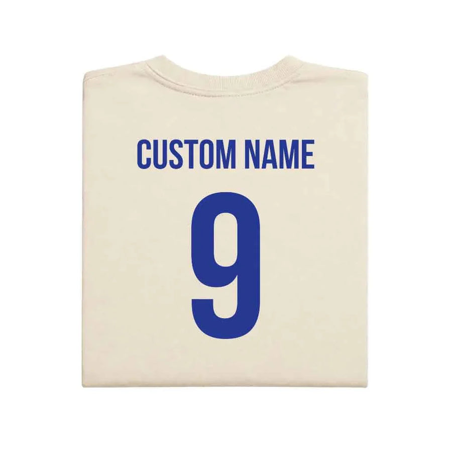May include a person wearing a cream 2026 World Cup T-shirt featuring bold soccer graphic and relaxed fit.