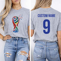 May include a person wearing a gray 2026 World Cup T-shirt featuring bold soccer graphic and relaxed fit.