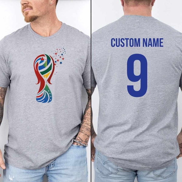 May include a person wearing a gray 2026 World Cup T-shirt featuring bold soccer graphic and relaxed fit.